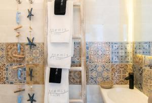 een badkamer met een handdoekenrek en een bad bij Anemis in Tinos Town