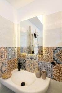 een badkamer met een wastafel en een spiegel bij Anemis in Tinos Town