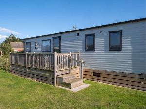 a mobile home with a porch and a deck at Pinewoods Park Style no.6 - sleeps 6 – no dogs in Wells next the Sea