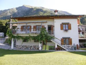 a large white house with a mountain in the background at Apartment Šavli in Kobarid