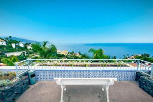 a white bench on a balcony overlooking the ocean at Bimba Studio Park in Santa Úrsula