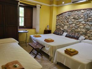 a room with two beds and a stone wall at HOTEL PASTERAL RIU TER in La Cellera de Ter +118 photos