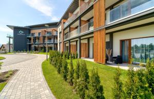 a building with a walkway next to a building at Laguna Beskidów Resort - Apartament Widokowa Przystań in Zarzecze