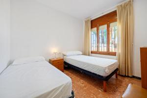 a bedroom with two beds and a window at Planta Baja La Malvarrosa in Benicarló
