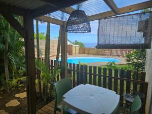 a patio with a table and chairs and a pool at L'Ile en Ylang in Saint-Leu