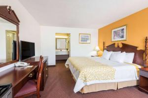 a hotel room with a bed and a desk at Days Inn by Wyndham Amherst in Amherst