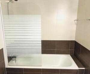 a bath tub in a bathroom with brown tile at El Rincón de Lupe in Mogro +11 photos