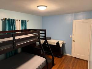 a room with two bunk beds and a door to a bedroom at La Casa Bonita Near NYC in Yonkers