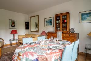 a dining room with a table with plates and glasses at Appartement Arcico - Welkeys in Boulogne-Billancourt