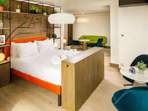a hotel room with a bed and a table and chairs at ibis Styles Edinburgh St Andrew Square in Edinburgh