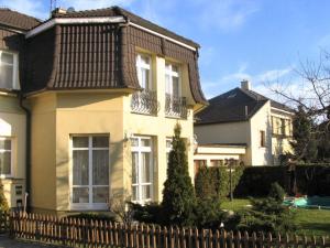 ein weißes Haus mit einem Zaun davor in der Unterkunft Villa Olivia in Prag