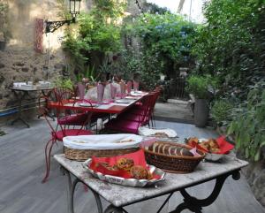 a table with plates of food on it with chairs at No2 La Place in Tourbes