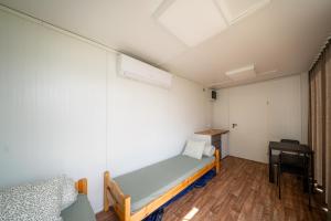 a small bedroom with a bed and a desk at BoardHouse Spot in Svencelė