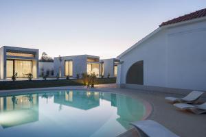a house with a swimming pool next to a building at L'École Eco Resort in Água Travessa