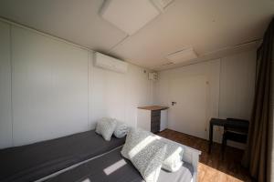 a small room with a bed and a table at BoardHouse Spot in Svencelė +4 photos