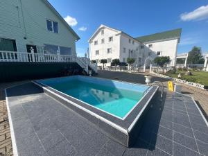 a swimming pool on a patio next to a house at Tatjanos Dvaras in Vilnius