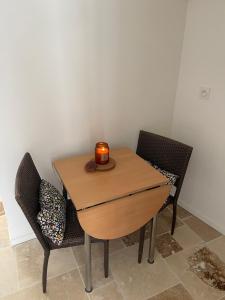 a wooden table with two chairs and a candle on it at L'échappée belle in Le Pouget