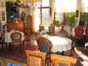 a dining room with tables and chairs and a chandelier at Villa Olivia in Prague