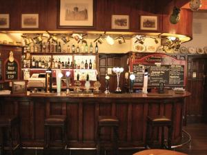 a bar in a pub with stools and bottles of alcohol at Masons Arms in York