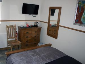 a bedroom with a bed and a tv and a chair at Masons Arms in York +6 photos