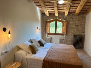 a bedroom with a large bed in a room with a window at Can Casellas in Palau Sator