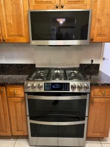 a kitchen with a stove with a microwave above it at La Casa Bonita Near NYC in Yonkers