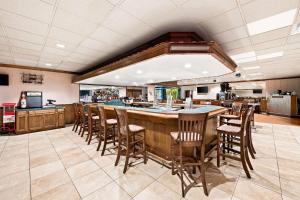 a large kitchen with a bar with wooden chairs at Quality Inn Dayton Airport in Englewood