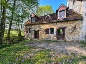 an old stone house sitting on top of a field at Ancien moulin avec piscine, terrasse, jardin privatif et petite île - près des étangs de la Brenne - FR-1-591-159 in Prissac