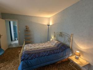 una camera da letto con un letto con un piumone blu di Maison spacieuse avec cour et cheminée au cœur du Parc Naturel de la Brenne - FR-1-591-229 a Mézières-en-Brenne