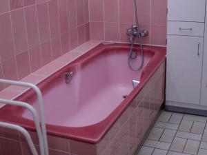 a pink bath tub in a pink tiled bathroom at Gîte au cœur d'Artenay – 3 chambres, tout confort, à 25 min d'Orléans, proche commerces et musées - FR-1-590-123 in Artenay +27 photos