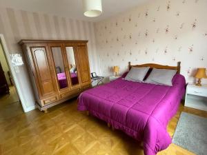 a bedroom with a bed with a purple bedspread at Gîte au cœur d'Artenay – 3 chambres, tout confort, à 25 min d'Orléans, proche commerces et musées - FR-1-590-123 in Artenay