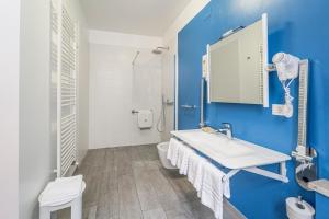 a bathroom with a white sink and a blue wall at Hotel Italia in Trieste