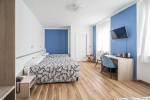 a hotel room with a bed and a desk at Hotel Italia in Trieste