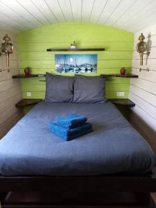 Bett mit blauem Handtuch auf einem Zimmer in der Unterkunft Roulotte au pied du Mont Saint Michel in Pontorson