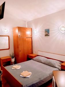 a small bedroom with a bed and a cabinet at Rooms Helena in Krk