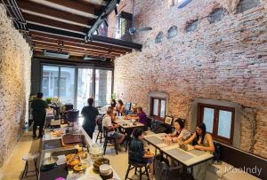 a group of people sitting at tables in a restaurant at KLUENNGAM Cafe & Stay in Songkhla