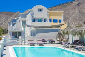 una casa con piscina di fronte a un edificio di Perissa BeachFront Rooms a Perissa