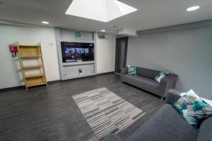 a living room with a couch and a tv at Captivating 1-Bed studio in Birmingham in Birmingham