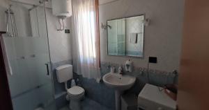 un bagno con lavandino, WC e specchio di holiday home LG a San Vito lo Capo Altre 22 foto