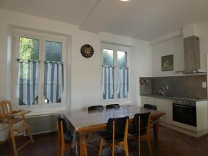 a kitchen with a table and chairs and a clock on the wall at Maison de caractère avec jardin clos, idéale pour familles, proche sentiers de randonnée - FR-1-581-88 in Nonvilliers-Grandhoux