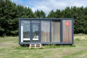 a tiny house sitting on top of a field at BoardHouse Spot in Svencelė