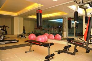 a gym with a lot of exercise equipment and a mirror at Acar Hotel in Alanya