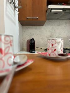 two coffee cups sitting on a table in a kitchen at A 2 passi dal blu in Roseto degli Abruzzi +23 photos