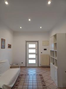 a white room with a bed and a door at A 2 passi dal blu in Roseto degli Abruzzi