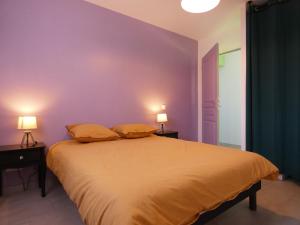 une chambre avec un grand lit aux murs violets dans l'établissement Maison rénovée avec jardin, 3 chambres, à 10 min de Chartres, idéale pour familles et escapades romantiques - FR-1-581-114, à Thivars