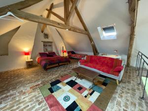un soggiorno con divano rosso e tappeto di Maison de Charme en Sologne avec Étang Privé, Grand Parc et Cheminée - FR-1-586-37 a Sainte-Montaine