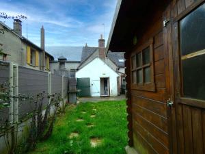 a yard with a fence and a white house at Escapade Paisible: Gîte pour 8 à Saint-Hilaire-sur-Yerre, Jardin Clos, Proche Chateaudun et Chartres - FR-1-581-131 in Saint-Hilaire-sur-Yerre
