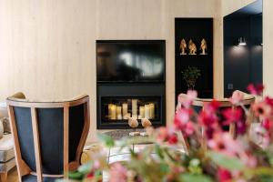 a living room with a fireplace and a tv at Hotel Naudi Boutique Adults only in Soldeu
