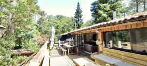 a cabin in the woods with a large deck at Tres belle maison en bois,dans la Marina, 10pers, au bord de leau in Lacanau