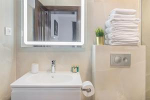 Un baño con lavabo, espejo y toallas. en Thermalis Groove, en Băile Felix